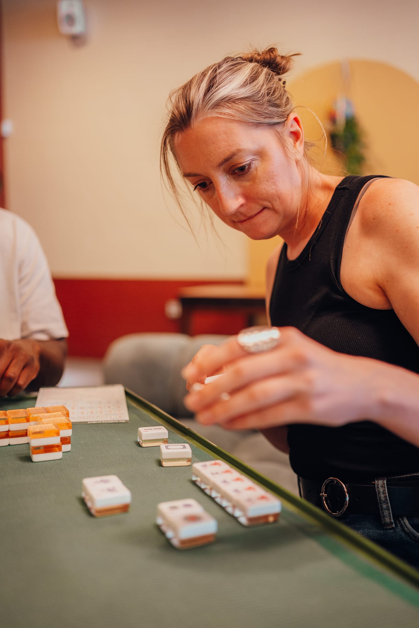 Player studying her mahjong tiles