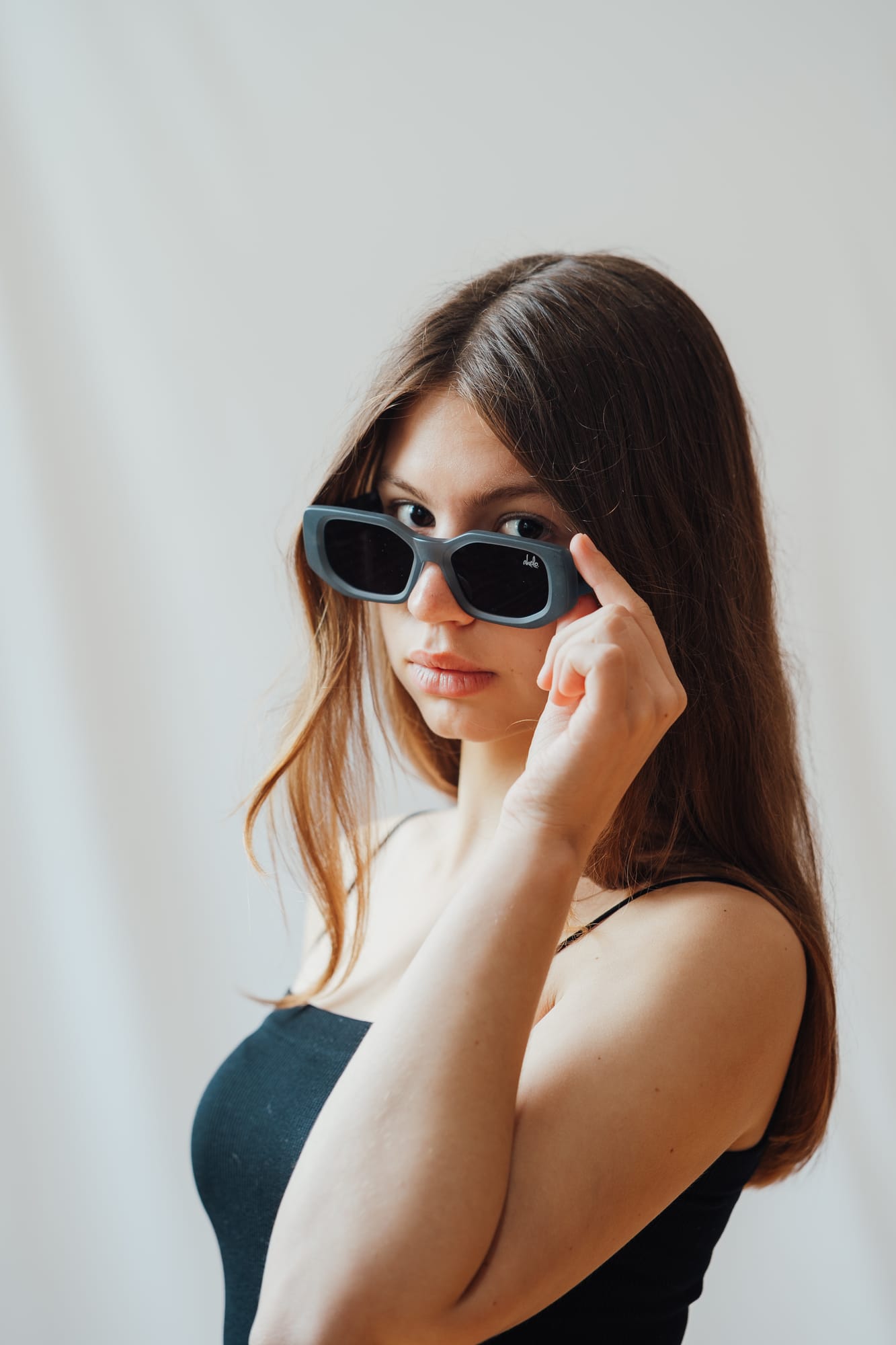 Woman lowering her sunglasses toward the camera